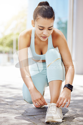 Image of Fitness, sports and shoes of woman in road for running, health and morning workout. Exercise, motivation and training with girl runner fixing her sneakers for wellness, summer and sports in street