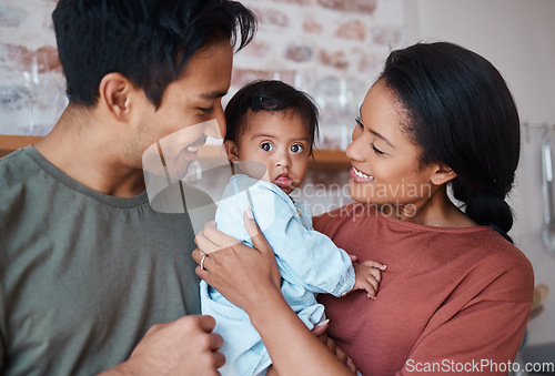 Image of Love, happy parents and baby with down syndrome in the kitchen embracing and bonding in their home. Happiness, smile and family care with special needs or disabled child standing together in a house.