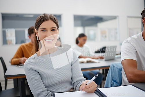 Image of Education, university student and girl writing in classroom, lecture notes or studying for paper test. Learning, college and happy female smile with notebook and pen, exam or essay assignment on desk