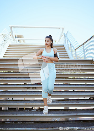 Image of Fitness, smartwatch and health tracking with sports woman checking pulse and progress during exercise on building steps in a city. Training, time and cardio workout by Mexican girl monitor wellness