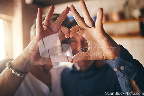 Image of Love, hands and heart sign with senior couple relax and bonding in their home together, cheerful and in love. Support, soulmate and loving man and woman sharing romantic moment and enjoy relationship