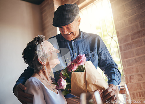 Image of Love, flowers and gift of a senior couple in celebration, joy and happiness of a birthday, anniversary or milestone. Elderly man and woman, happy, romantic and smiling together in a retirement home