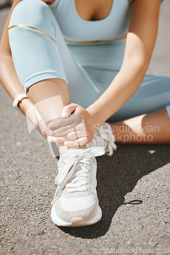 Image of Sports, injury and fitness ankle pain during exercise, running and training outside with muscle or joint. Woman, risk and hurt hands athlete holding broken leg bone with bad bruise in the street