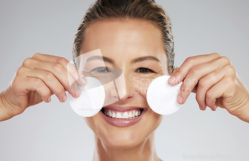 Image of Mature, model and skincare with pads by face in hands for cleaning in dermatology, beauty or facial portrait. Woman, smile and skin happy against studio backdrop for cosmetics, health and wellness