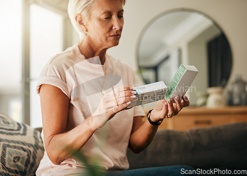 Image of Healthcare, retirement with woman and medicine in living room for wellness, medical and care. Senior, insurance and health with elderly person reading pills information for treatment prescription