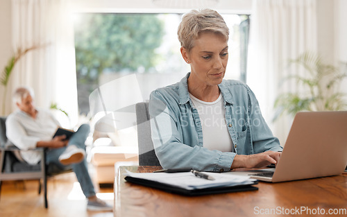 Image of Woman on laptop doing financial budget, taxes or planning monthly finance bank payment at home living room desk. Lady working remote on debt solution, typing on computer and husband reading a book