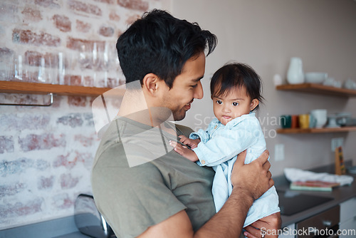 Image of Down syndrome, love and father with smile for baby in the kitchen of their house together. Young child with development disability and special needs with care from happy dad in their family home