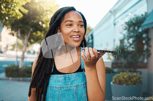Image of Black woman, speaker phone call and voice speech on microphone in Jamaica city street outdoor. Young millennial urban girl smartphone talking, loud audio chat ai application and mobile mic connection