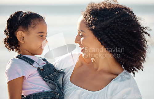 Image of Mom with child at beach smile, make eye contact and black family happiness. Black woman with girl, happy spend time as mother and daughter, on family holiday or vacation by the ocean in Brazil