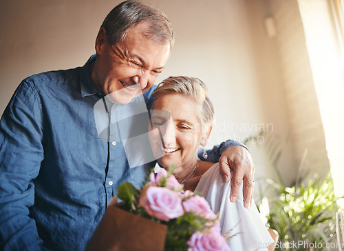 Image of Couple, romance and flowers with a senior man and woman in celebration of valentines day or their anniversary. Retirement, love and affection with an elderly male and female pensioner in their home