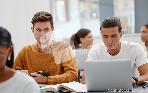Image of Education, laptop and student cheating in classroom working on test, exam or research. University, learning and college man writing notes, assignment or busy peeping on friends computer in lecture.