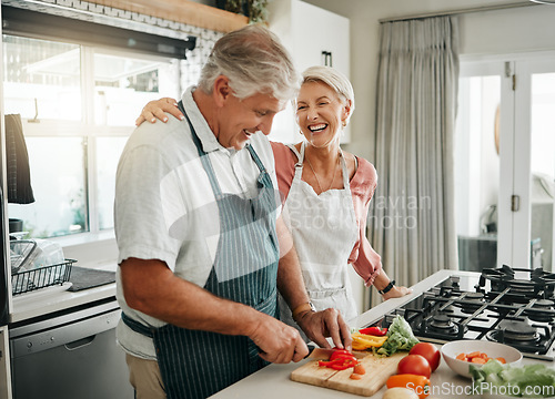 Image of Senior couple, cooking and having fun while preparing a healthy food with vegetables for a vegan meal in the kitchen at home while laughing and having fun. Funny old man and woman helping with dinner