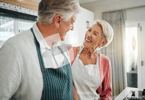 Image of Couple, cooking and love with a senior man and woman in the kitchen to prepare food or a meal at home. Retirement, happy and smile with an elderly male and female pensioner together in their house