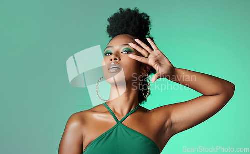 Image of Beauty, fashion and empowerment with a beautiful black woman in studio of a green background for style. Makeup, cosmetics and trendy with an edgy female model posing for individuality and equality