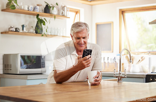 Image of Phone, kitchen and senior relax man doing internet, web or online search for meme, funny video or comedy. Retirement life, mobile and elderly person with coffee, tea and typing on social media app