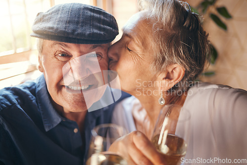 Image of Love, toast and old couple kiss with champagne in celebration of a happy marriage anniversary together at home. Smile, romance and senior woman enjoying a relaxing wine date and drink elderly partner