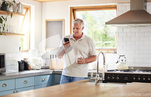 Image of Senior man, morning coffee and phone looking happy while reading text message, online news or browsing internet in kitchen at home. Male using messenger or social media mobile app in Australia house