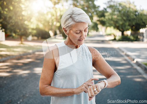 Image of Fitness runner or senior woman with smartwatch check exercise results, process or goal for healthy, wellness lifestyle. Elderly sports person on digital technology typing workout steps or data on arm