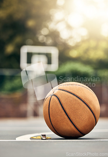 Image of A ball used for basketball on an outdoor basketball court in a park. Mockup for sport, training and getting ready to play a match for exercise. Summer, sports and playing games outside to keep fit