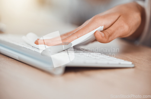 Image of Woman cleaning computer keyboard, covid safety and dust at office desktop workplace. Hands, cleaner and cloth wipe pc table for bacteria, dust and corona virus caution for sick workspace health risk