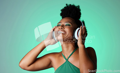 Image of Studio, happy and black woman in headphones with music playing from a Jamaican dance hall and reggae radio audio playlist. Freedom and young African girl enjoying listening fun, streaming and sounds