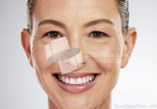 Image of Face makeup, beauty and mature woman with smile for skincare cosmetics against a grey mockup studio background. Portrait headshot of an elderly model happy about facial cosmetic care and wellness