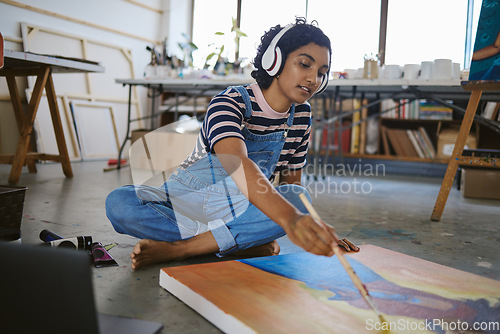 Image of Music, painting and art with woman on floor of workshop studio working on creative, idea or vision on canvas. Relax, designer and goals with girl artist and headphones for peace, wellness or freedom