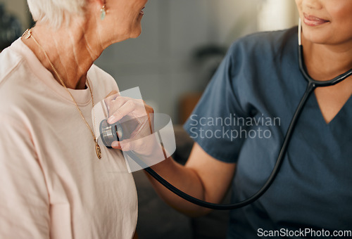 Image of Cardiology consultation, doctor and senior woman consulting about healthcare on living room sofa in retirement home. Hand of nurse with stethoscope while helping elderly patient with medical service