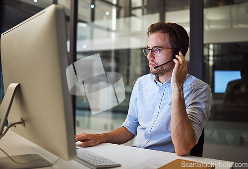 Image of Telemarketing, man and employee in call center with headphones at desk. Worker or consultant at table on computer talking to client, checking information or consulting customer with technical support