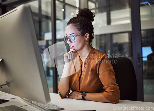 Image of Woman, computer and office with glasses show reflection on face while working overtime. Girl, thinking and idea read analytics, email or communication online at work late at business in the night