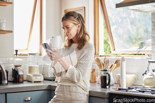 Image of Coffee, phone and senior woman in kitchen browsing social media, text message or online app at home. Relax, tea and reading news or mobile online web surfing with female from Canada on 5g smartphone