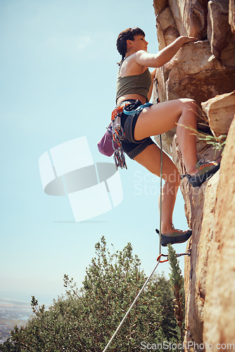 Image of Mountain, climbing and sport with a sports woman or athlete abseiling outdoor for health and fitness. Training, workout and exercise with a young female athlete or climber scaling a rocky cliff