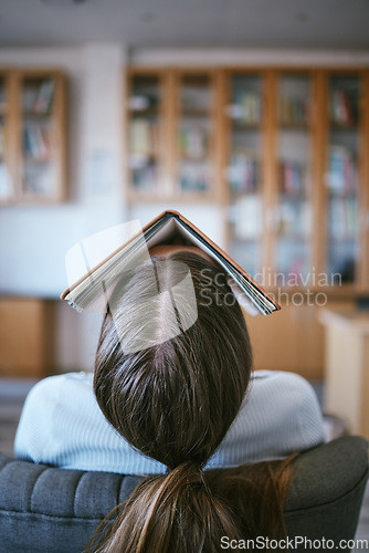 Image of Burnout, tired and sleeping student with book on face in university library learning, education or reading problem. Fatigue, frustrated or bored college woman and research studying for language exam