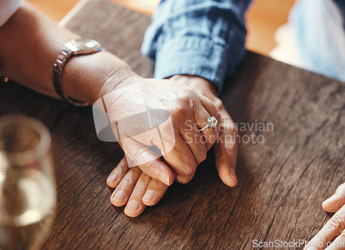 Image of Holding hands, date and couple with support at restaurant for celebration of love, marriage and anniversary. Man and woman with trust, care and gratitude at a cafe or coffee shop table for dinner