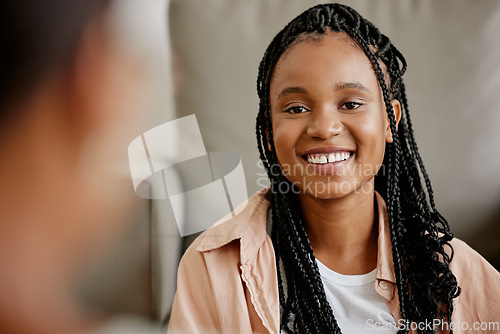 Image of Happy, black woman and smile of a person on a home couch with happiness and a friend. Female face from Houston on a living room sofa looking at a person in a conversation and listening in a house