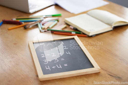 Image of Chalkboard, math or notebook in homeschool study at house in covid lockdown, quarantine or social distancing. Zoom, education question or learning support for students, children or kids on wood table