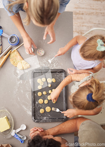 Image of Baking, family and girl children learning to bake cookies in kitchen at home from above with mom, dad and sister. Man, woman and kids having fun with dough, cooking and food together making pastry