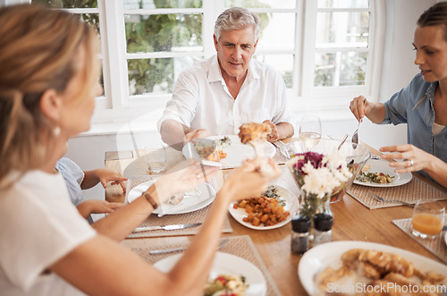 Image of Family, food and eating with a senior man at the dining room table with his relatives for a meal during a visit or celebration event. Happy, together and fresh with a hungry group of people at home