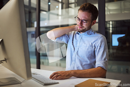 Image of Burnout, neck pain and tired with an exhausted businessman working on a computer in his office late at night. Stress, headache and problem with a male employee at work on a project deadline