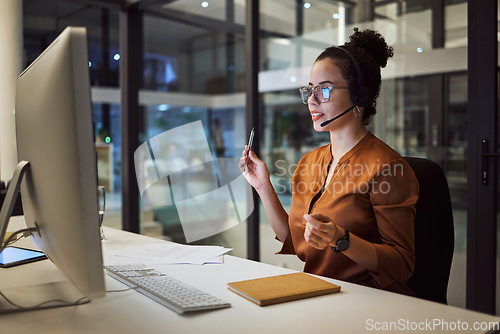 Image of Call center, customer support and insurance agent consulting at night in a office at a contact help desk. Sales, telemarketing and employee working hard in helping, talking and listening via headset