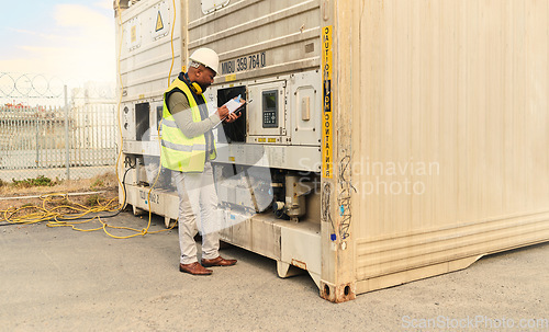 Image of Mechanic, black man and refrigerator checklist for container cargo maintenance at shipping yard. Professional stock distribution worker busy with technical notes for freight storage plant crate.