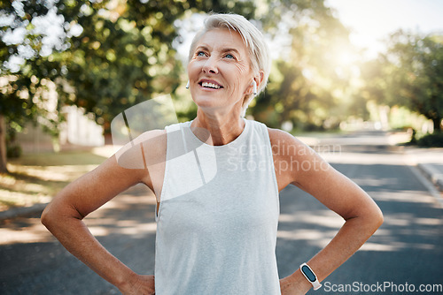 Image of Fitness senior woman with earphones and smartwatch for her outdoor exercise, listening to music or motivation podcast with 5g technology. Healthy elderly person or runner happy with workout results