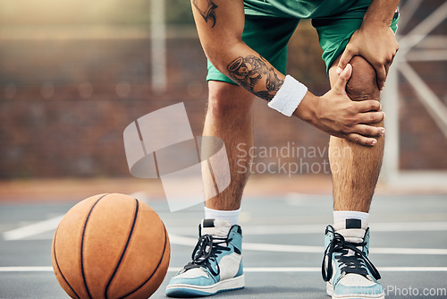 Image of Basketball, athlete and knee injury on the basketball court during outdoor game or training. Man in with leg pain after sports accident with a broken joint, inflammation or muscle tear during match.