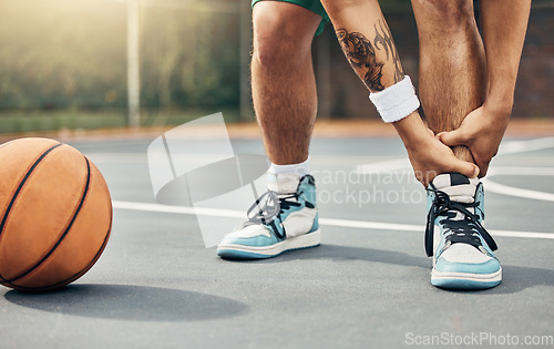 Image of Basketball, ankle in pain and injury from sports or accident on the court in a fitness game or training match outdoors. Athlete suffering with muscle inflammation, hurt leg joint or a broken bone