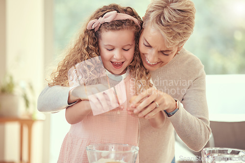 Image of Children, family and baking with a girl learning and grandmother cooking in a kitchen of their home together. Kids, food and ingredients with a senior woman teaching her granddaughter to make a meal