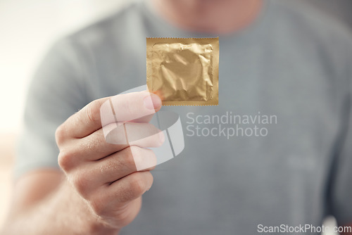 Image of Condom in man hand for safe sex, sexual safety and hiv awareness zoom. Person with male contraceptive product for sexual risk prevention, healthcare and caution for security, trust and love choice