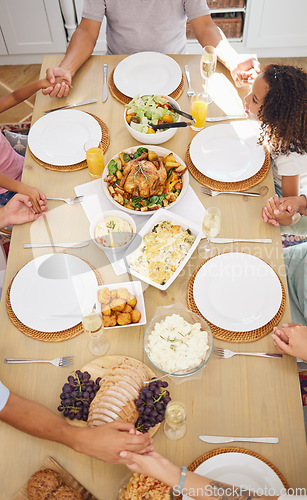 Image of Pray, food and family friends dinner at a table with gratitude, love and religion faith before eating. Praying at a meal as a spiritual and christian practice holding hands together for worship