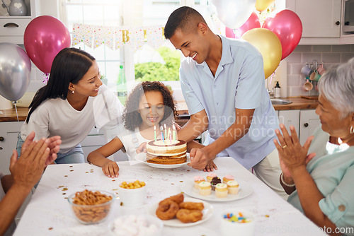 Image of Child, birthday cake and celebration party with family and parents of a happy and excited girl ready to blow her candles at home. Cute kid at a table in her Puerto Rico house with balloons and snacks