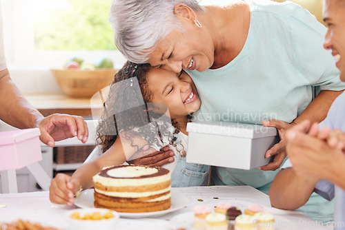 Image of Hug, happy and gift giving of a grandmother and girl with birthday cake at a party celebration. Happiness of people at a children event to celebrate with food, family and friends smile at a home