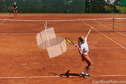 Image of Young girls in a lively tennis match on a sunny day, demonstrating their skills and enthusiasm on a modern tennis court.